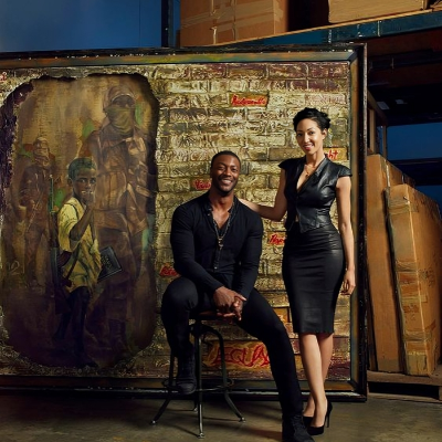 Aldis and Harmonia taking a picture in front of an abstract painting.